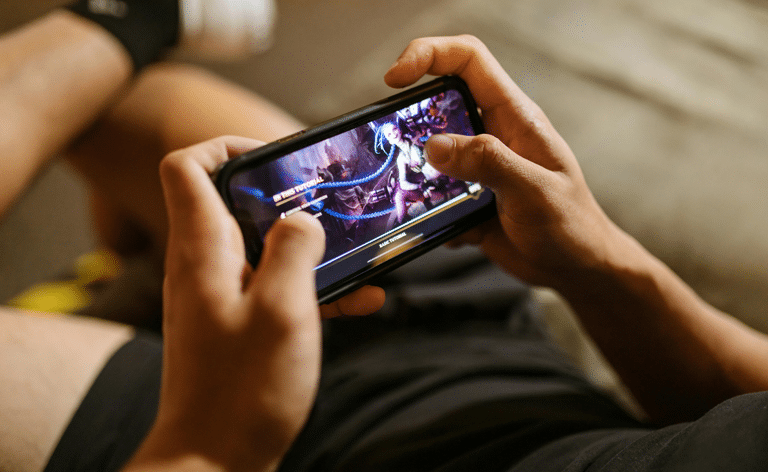 zoom sur les mains d'une personne jouant à un jeu vidéo sur un smartphone